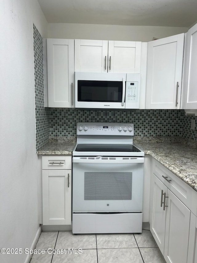 4841 NW 7th St Unit 203-4, Miami, FL 33126 - kitchen featuring white appliances, white cabinetry, tasteful backsplash, light stone counters, and light tile patterned floors
