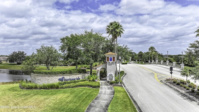 6008 Van Ness Dr, Melbourne, FL 32940 - view of road featuring a gated entry, sidewalks, and curbs