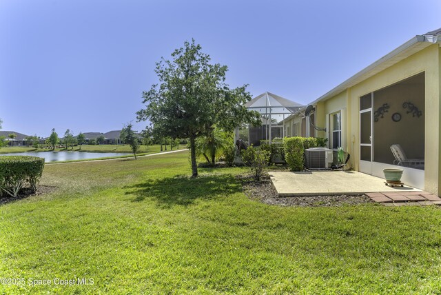 6008 Van Ness Dr, Melbourne, FL 32940 - view of yard featuring glass enclosure, a water view, cooling unit, and a patio