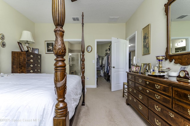 6008 Van Ness Dr, Melbourne, FL 32940 - bedroom with a walk in closet, light carpet, a textured ceiling, and visible vents