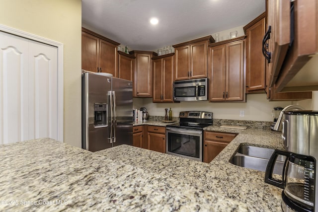 6008 Van Ness Dr, Melbourne, FL 32940 - kitchen with brown cabinets, recessed lighting, appliances with stainless steel finishes, and light stone counters