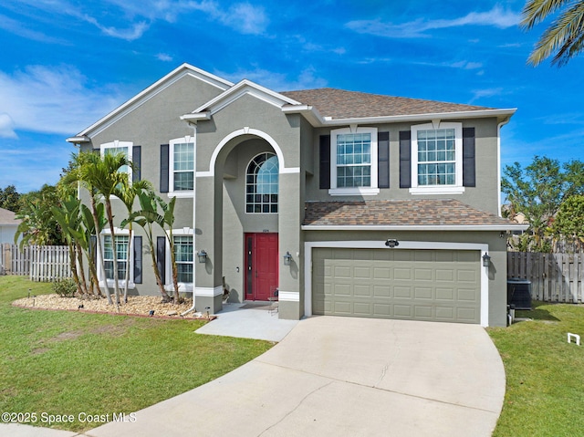 traditional home with an attached garage, a front yard, stucco siding, and fence