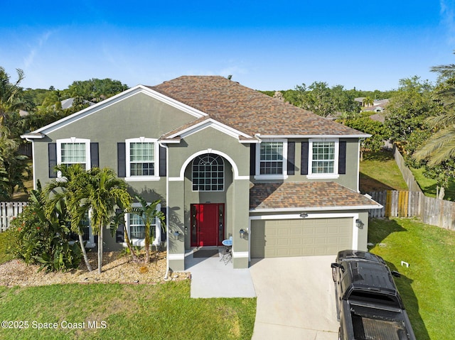 traditional-style house with stucco siding, fence, a garage, driveway, and a front yard