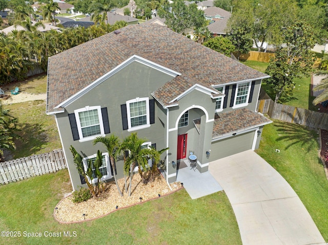 view of front of home with driveway, roof with shingles, stucco siding, a front lawn, and a garage