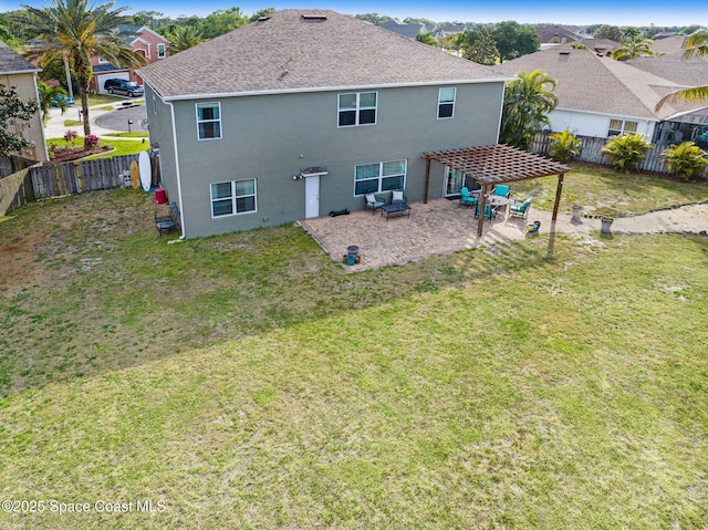 rear view of house featuring stucco siding, a pergola, a lawn, and a fenced backyard