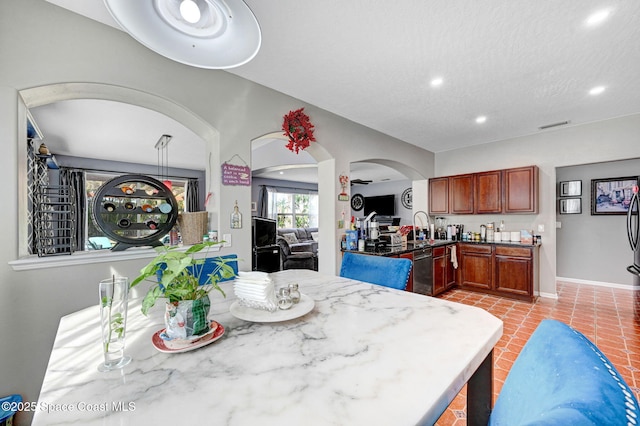 dining space with light tile patterned flooring, recessed lighting, baseboards, and arched walkways