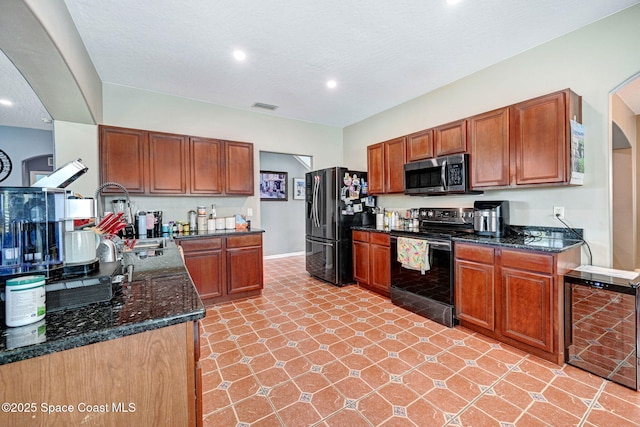 kitchen featuring recessed lighting, stainless steel microwave, range with electric cooktop, black refrigerator with ice dispenser, and visible vents