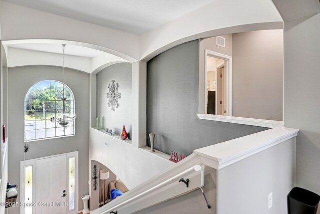 foyer entrance featuring arched walkways and visible vents