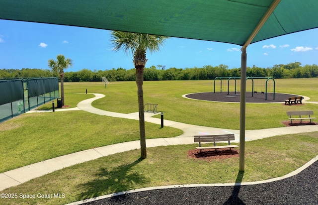 view of home's community with a lawn and playground community