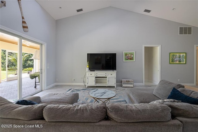 living area with high vaulted ceiling, baseboards, and visible vents