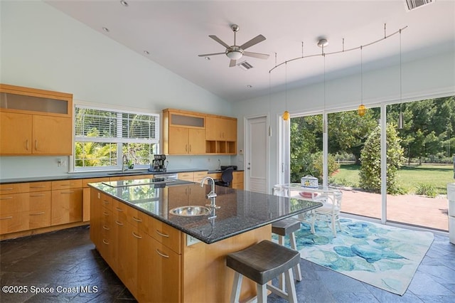 kitchen with stone tile floors, a sink, open shelves, and lofted ceiling