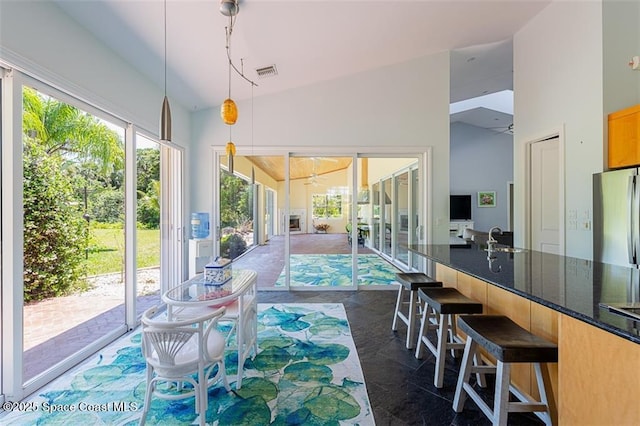 interior space with visible vents, ceiling fan, and high vaulted ceiling