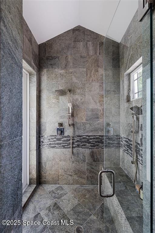 full bath with a shower stall and lofted ceiling