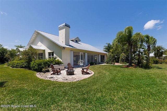 rear view of property featuring an outdoor fire pit, a yard, a patio, and metal roof