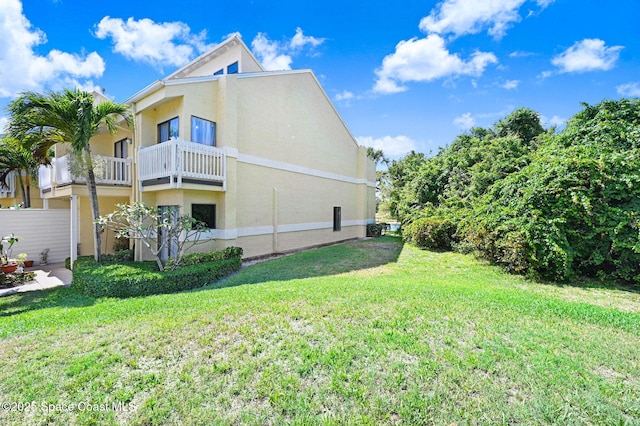 view of home's exterior with stucco siding and a yard