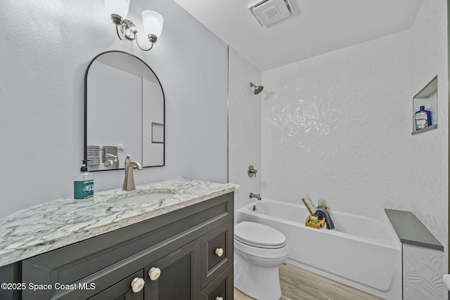 full bath featuring visible vents, bathtub / shower combination, wood finished floors, vanity, and toilet