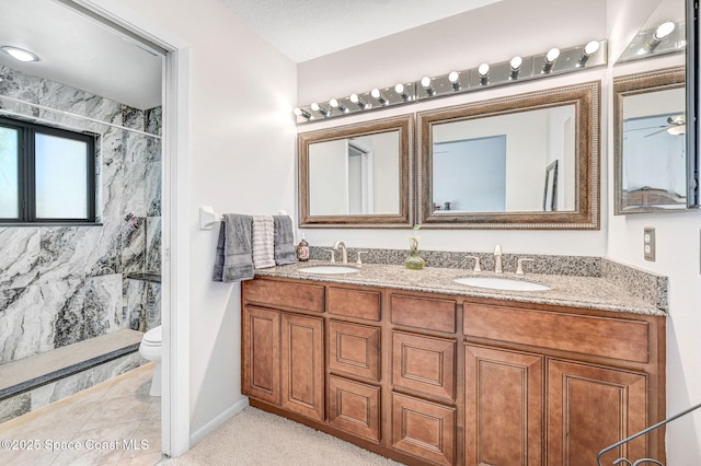 full bath featuring a sink, double vanity, toilet, and a shower