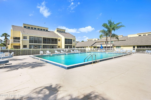 community pool featuring a patio and fence
