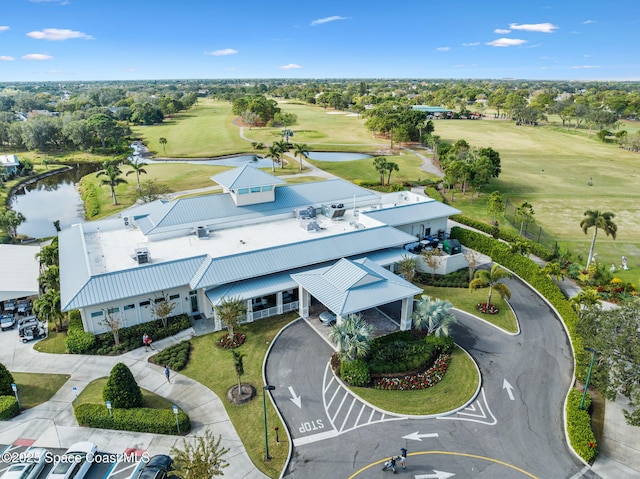 drone / aerial view with a water view and view of golf course
