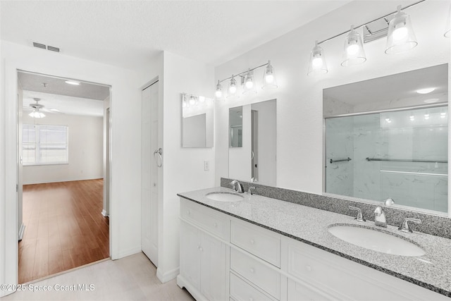 104 Riverside Dr Unit 402, Cocoa, FL 32922 - full bath with a sink, ceiling fan, a shower with shower door, and visible vents