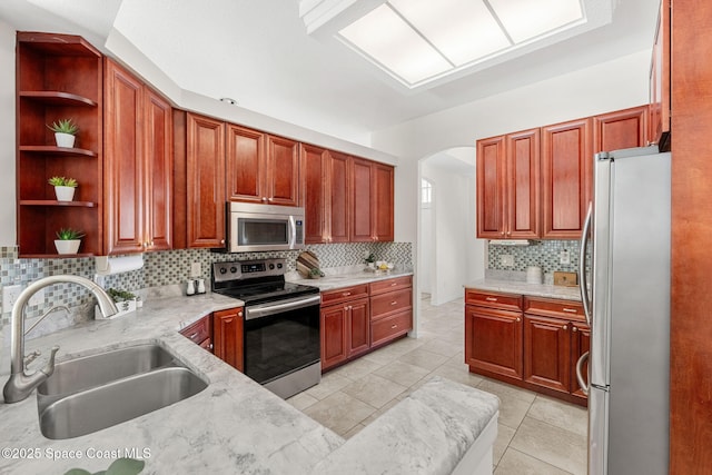 2100 Weatherly Ave, Melbourne, FL 32904 - kitchen featuring open shelves, appliances with stainless steel finishes, a sink, arched walkways, and backsplash