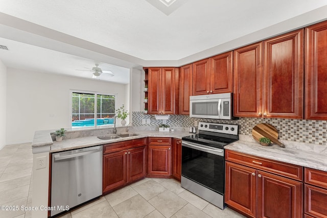 2100 Weatherly Ave, Melbourne, FL 32904 - kitchen with appliances with stainless steel finishes, light stone counters, a sink, light tile patterned floors, and backsplash