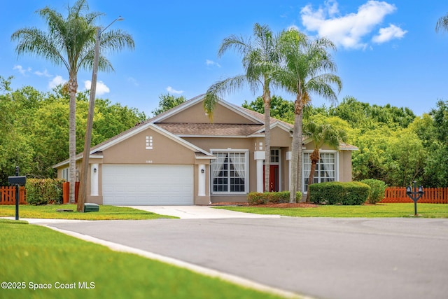 2100 Weatherly Ave, Melbourne, FL 32904 - ranch-style house with an attached garage, fence, driveway, and stucco siding