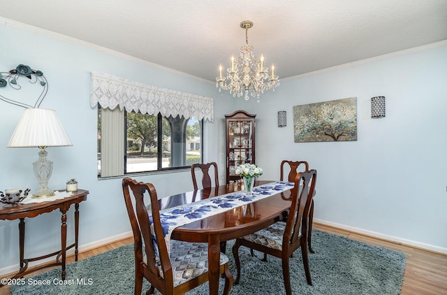 dining room with crown molding, baseboards, an inviting chandelier, and wood finished floors
