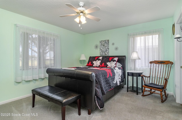 carpeted bedroom featuring baseboards and a ceiling fan