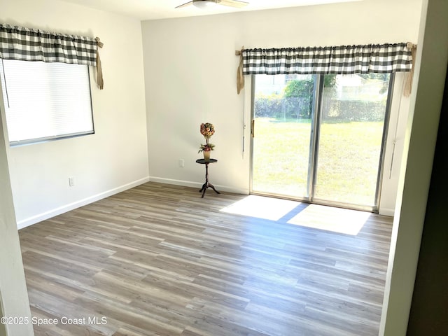 unfurnished room featuring baseboards, wood finished floors, and ceiling fan