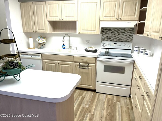 kitchen featuring white appliances, light wood-style flooring, open shelves, light countertops, and a sink