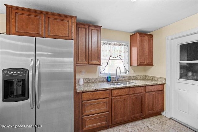 15 Skyline Blvd, Merritt Island, FL 32953 - kitchen featuring stainless steel fridge, a sink, light stone countertops, and brown cabinetry