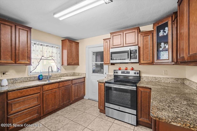 15 Skyline Blvd, Merritt Island, FL 32953 - kitchen featuring appliances with stainless steel finishes, a sink, light stone countertops, and light tile patterned floors