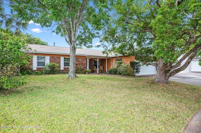 ranch-style house featuring a garage, driveway, a front lawn, and brick siding