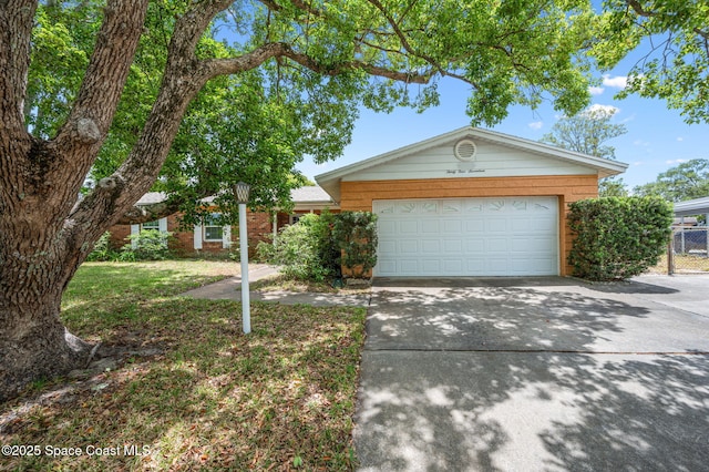 single story home featuring fence, an attached garage, and concrete driveway