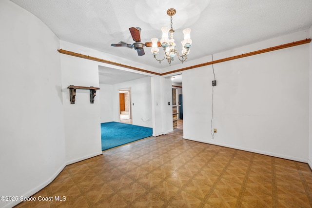 unfurnished room with a textured ceiling, baseboards, and a chandelier