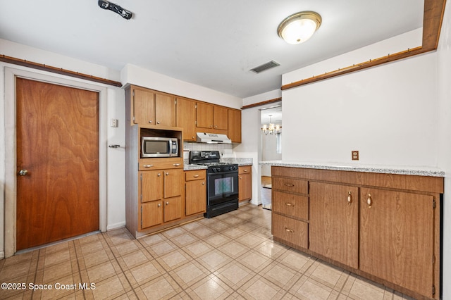 kitchen with light countertops, brown cabinetry, stainless steel microwave, black gas stove, and visible vents