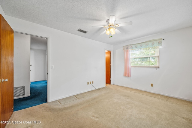 unfurnished bedroom with visible vents, a textured ceiling, baseboards, and carpet floors