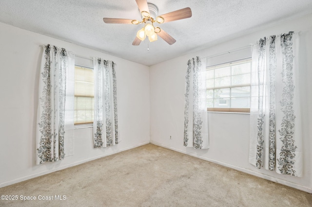spare room with a ceiling fan, carpet flooring, and a textured ceiling