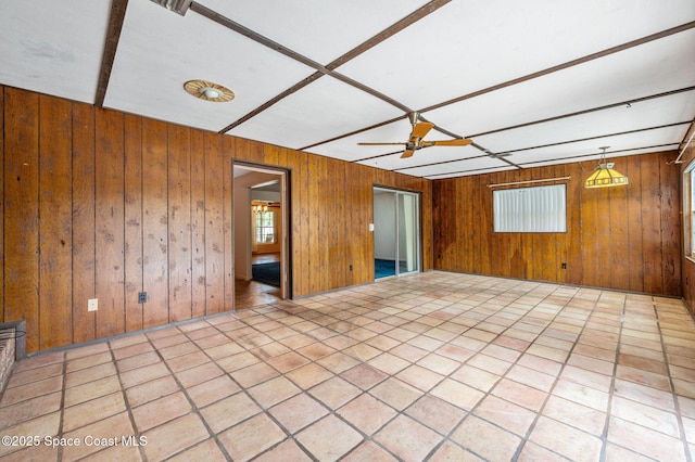spare room with wooden walls and ceiling fan
