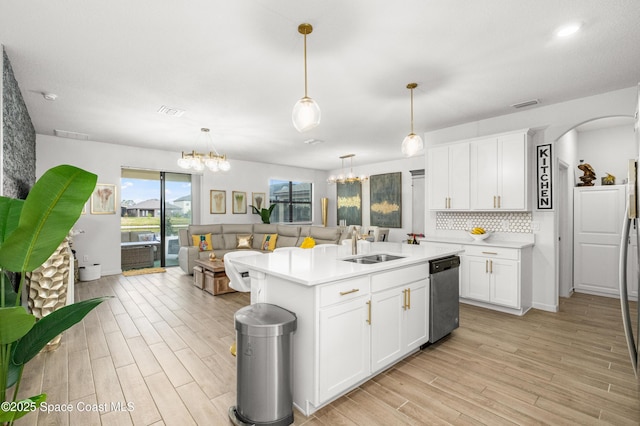 kitchen with a sink, stainless steel dishwasher, visible vents, light countertops, and light wood-style floors