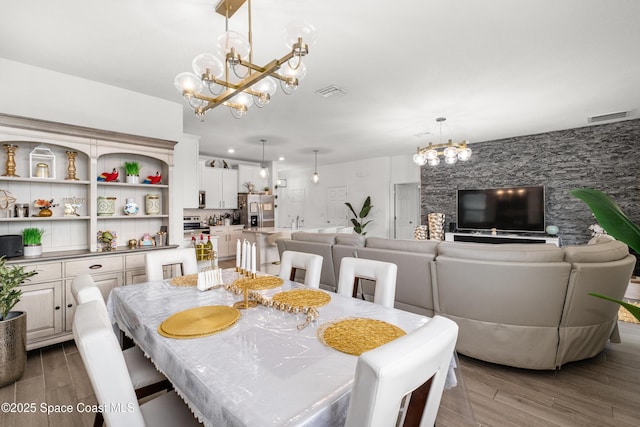 dining area featuring a chandelier, visible vents, and wood finished floors