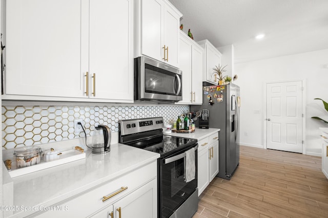 kitchen with decorative backsplash, light wood-style floors, light countertops, white cabinets, and appliances with stainless steel finishes