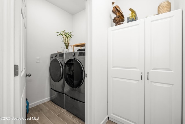 washroom with wood tiled floor, baseboards, laundry area, and washer and clothes dryer
