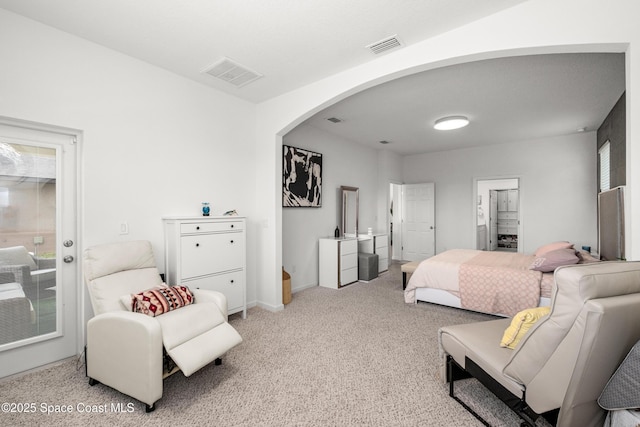 bedroom with carpet flooring, arched walkways, and visible vents
