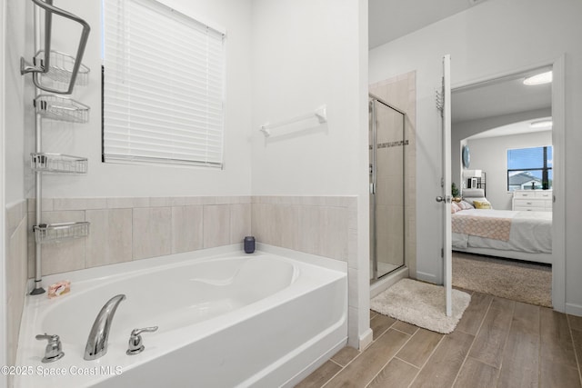 ensuite bathroom with a stall shower, ensuite bath, a garden tub, and wood finished floors