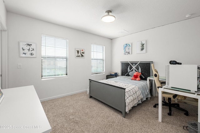 bedroom with baseboards and light carpet