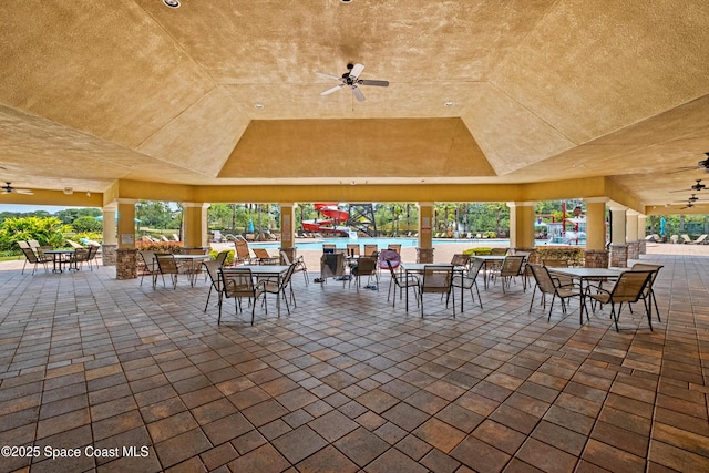 view of patio / terrace featuring a community pool, a ceiling fan, and outdoor dining space