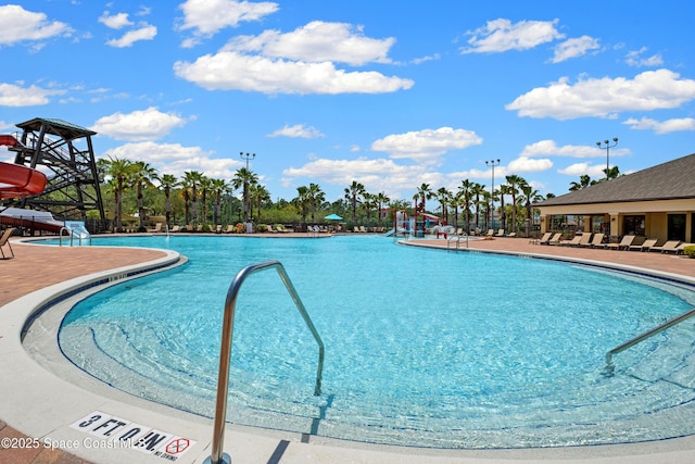 pool with a patio and a water slide