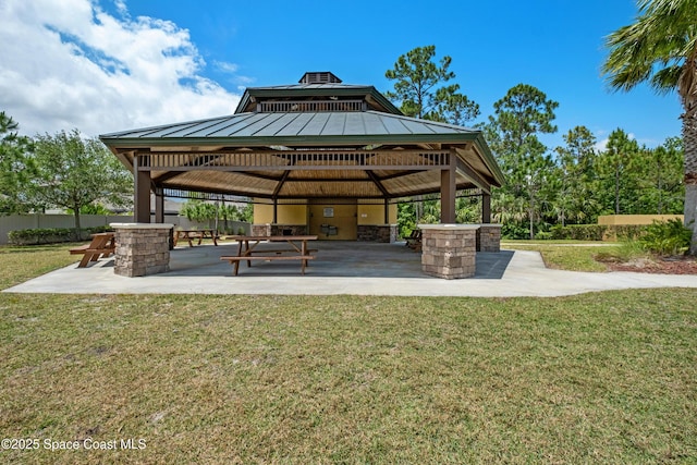 view of property's community featuring a lawn, a gazebo, a patio, and fence